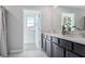 Bathroom with dual vanities, a large mirror, and a bright window, creating a clean and inviting space at 3338 Ivy Hollow Dr, Plant City, FL 33565