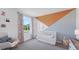 Charming Bedroom with a white crib, cozy rocker, and playful geometric wall design at 3338 Ivy Hollow Dr, Plant City, FL 33565