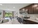Modern kitchen with stainless steel appliances, dark wood cabinets, and adjacent dining area with scenic views at 3338 Ivy Hollow Dr, Plant City, FL 33565