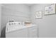 Bright laundry room with modern washer, dryer, and convenient overhead shelving at 3516 Rosewood Ramble Ct, Plant City, FL 33565