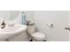 Half bathroom features a pedestal sink, toilet, and modern fixtures at 35853 Buttonweed Trl, Zephyrhills, FL 33541