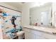 Well-lit bathroom with a whimsical shower curtain and a clean, functional layout at 35853 Buttonweed Trl, Zephyrhills, FL 33541