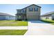 Two-story home featuring a well-kept lawn, two-car garage, and neutral-toned exterior at 35853 Buttonweed Trl, Zephyrhills, FL 33541