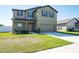 Two-story home featuring a well-kept lawn, two-car garage, and neutral-toned exterior at 35853 Buttonweed Trl, Zephyrhills, FL 33541