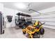 Spacious garage featuring a golf cart, lawn mower, and plenty of room for storage at 35853 Buttonweed Trl, Zephyrhills, FL 33541