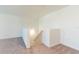 Bright hallway with neutral carpet and staircase, offering a clean and inviting transition between spaces at 35853 Buttonweed Trl, Zephyrhills, FL 33541