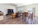 Spacious living room with a ceiling fan, large windows, wood-look floors and a view of the lake at 35853 Buttonweed Trl, Zephyrhills, FL 33541