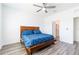 Primary bedroom features a ceiling fan, wood-look floors, and access to an ensuite bathroom at 35853 Buttonweed Trl, Zephyrhills, FL 33541