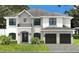Elegant two-story home featuring stone accents, a gray roof, and a two-car garage with a beautiful lawn at 3910 W San Carlos St, Tampa, FL 33629