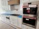 Modern kitchen featuring stainless steel appliances, white herringbone tile backsplash, and beautiful white cabinetry at 3910 W San Carlos St, Tampa, FL 33629