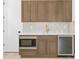 A refreshment center features a stainless steel refrigerator, microwave, and custom cabinetry at 3910 W San Carlos St, Tampa, FL 33629