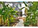 Lush backyard with tropical foliage, brick patio, stepping stone pathway, and plenty of privacy at 404 Danube Ave, Tampa, FL 33606