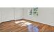 Bright bedroom featuring hardwood floors, white walls, and a window with a view of lush greenery at 404 Danube Ave, Tampa, FL 33606