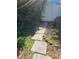 A stone walkway through the tropical landscaping and native foliage with gate to the side at 414 Danube Ave, Tampa, FL 33606