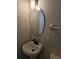 This bathroom features a pedestal sink with an oval mirror and modern light fixture at 414 Danube Ave, Tampa, FL 33606