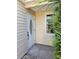 Inviting front door with decorative glass, complemented by neutral siding and a trimmed green bush at 414 Danube Ave, Tampa, FL 33606