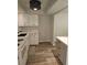Bright kitchen boasts white cabinets, grey island, new floors, and contemporary light fixture at 414 Danube Ave, Tampa, FL 33606