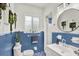 White and blue bathroom featuring a sink, toilet, mirror and succulent wall hangings at 420 48Th N St, St Petersburg, FL 33713
