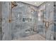 The shower features dual shower heads, a built in niche, and pebble-look flooring for a spa like experience at 420 48Th N St, St Petersburg, FL 33713