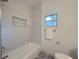 Modern bathroom showcasing a sleek bathtub, tiled walls, and a convenient in-wall niche at 5105 68Th N Way, St Petersburg, FL 33709