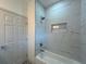 Modern bathroom featuring sleek white tiling, a niche for storage, and a relaxing bathtub at 5105 68Th N Way, St Petersburg, FL 33709
