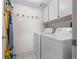 Laundry room with washer, dryer, and overhead cabinets for storage at 5155 Isla Key S Blvd # 304, St Petersburg, FL 33715