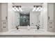 Bathroom featuring double sinks, granite counters, stylish lighting, and custom cabinetry at 5240 Coquina Key Se Dr # B, St Petersburg, FL 33705