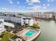 A white condo complex featuring a pool with waterfront views under a blue sky, as indicated by the red arrow at 5960 30Th S Ave # 414, Gulfport, FL 33707