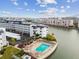 A white condo complex featuring a pool and waterfront views under a blue sky at 5960 30Th S Ave # 414, Gulfport, FL 33707