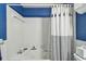 Clean bathroom with white tiled walls and blue accents; shower and tub combination at 5960 30Th S Ave # 414, Gulfport, FL 33707