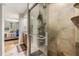Bathroom with glass enclosed shower, tiled walls, and a view into the Primary bedroom at 6821 Mary Lou Ln, Wesley Chapel, FL 33544