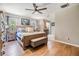 Bright bedroom with a ceiling fan, wood floors, and ensuite bathroom access for added convenience at 6821 Mary Lou Ln, Wesley Chapel, FL 33544