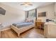 Cozy bedroom featuring a ceiling fan, desk, and a window with natural light at 6821 Mary Lou Ln, Wesley Chapel, FL 33544