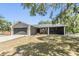 Charming single-story home featuring an attached garage, gray exterior, and a well-maintained front yard at 6821 Mary Lou Ln, Wesley Chapel, FL 33544
