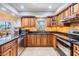 Well-lit kitchen showcasing custom cabinetry, granite countertops, stainless steel appliances, and tile flooring at 6821 Mary Lou Ln, Wesley Chapel, FL 33544