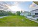 View of grassy backyard and neighboring houses under a partly cloudy sky at 6822 Kissimmee St # 8-B, Tampa, FL 33616