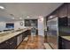 Well-lit kitchen featuring dark wood cabinetry, granite countertops, and stainless steel appliances at 6822 Kissimmee St # 8-B, Tampa, FL 33616