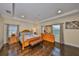 Bright main bedroom with hardwood floors, a wooden bed frame, and window views at 6822 Kissimmee St # 8-B, Tampa, FL 33616