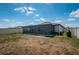 View of the backyard with a screened-in patio, lush green grass, and a fence surrounding the property at 7202 Ozello Trail Ave, Ruskin, FL 33573