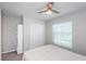 Cozy bedroom with a ceiling fan, window for natural light, closet, and additional shelving for storage at 7202 Ozello Trail Ave, Ruskin, FL 33573