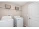 Bright laundry room with washer, dryer, overhead shelving, and a convenient layout at 7202 Ozello Trail Ave, Ruskin, FL 33573