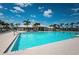 Community pool surrounded by palm trees, lounge chairs, and clear blue skies at 7202 Ozello Trail Ave, Ruskin, FL 33573