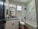 Modern bathroom with white vanity, granite countertop, tub and decorative tile at 7208 N Glen Ave, Tampa, FL 33614