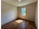 The bedroom features a herringbone floor and a window that provides natural light at 7208 N Glen Ave, Tampa, FL 33614