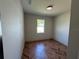 This bedroom features a herringbone floor and a window allowing natural light at 7208 N Glen Ave, Tampa, FL 33614