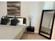 Comfortable bedroom with a stylish bed, decorative mirror, and natural light at 7208 N Glen Ave, Tampa, FL 33614