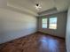 Bedroom featuring tray ceiling, recessed lighting and herringbone floors with two large windows at 7208 N Glen Ave, Tampa, FL 33614