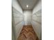 Walk-in closet featuring custom shelving and herringbone floors for ample storage at 7208 N Glen Ave, Tampa, FL 33614