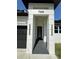 Front entryway with a large black door, gray tile, and modern stone pillars at 7208 N Glen Ave, Tampa, FL 33614