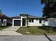 Charming single-story home featuring a black garage door and well-maintained landscaping at 7208 N Glen Ave, Tampa, FL 33614